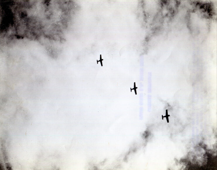 Three Grumman Wildcat Fighting planes flying over Guadalcanal’s Henderson field.