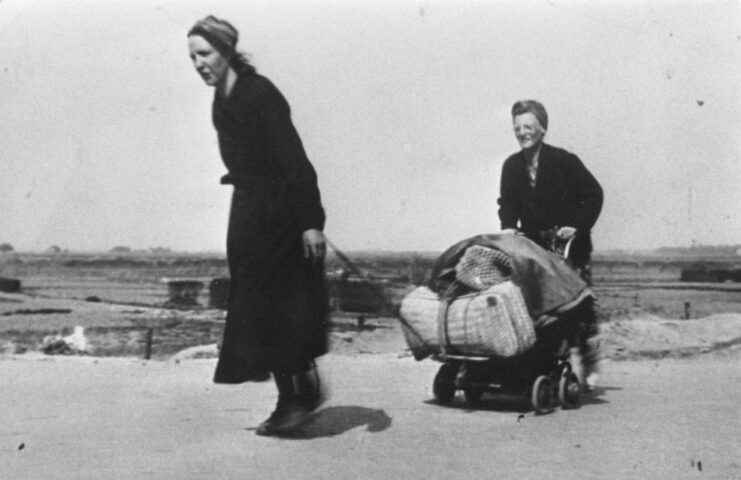 Two women using a wagon to transport food