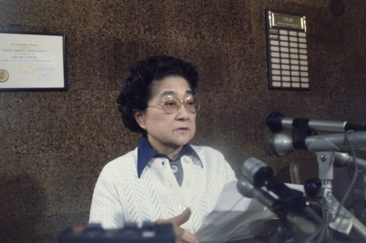 Iva Toguri D'Aquino speaking at a press conference. 