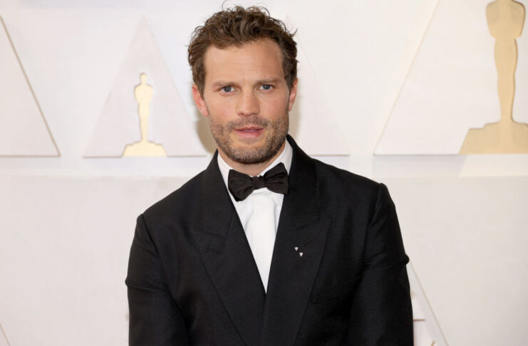 Jamie Dornan standing on a red carpet