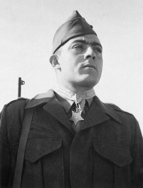 John Basilone standing in his US Marine Corps uniform, wearing his Medal of Honor