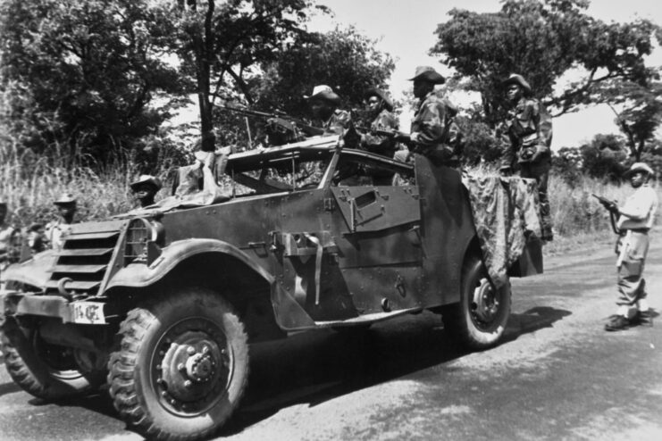 Katangese troops with machine guns standing around a vehicle