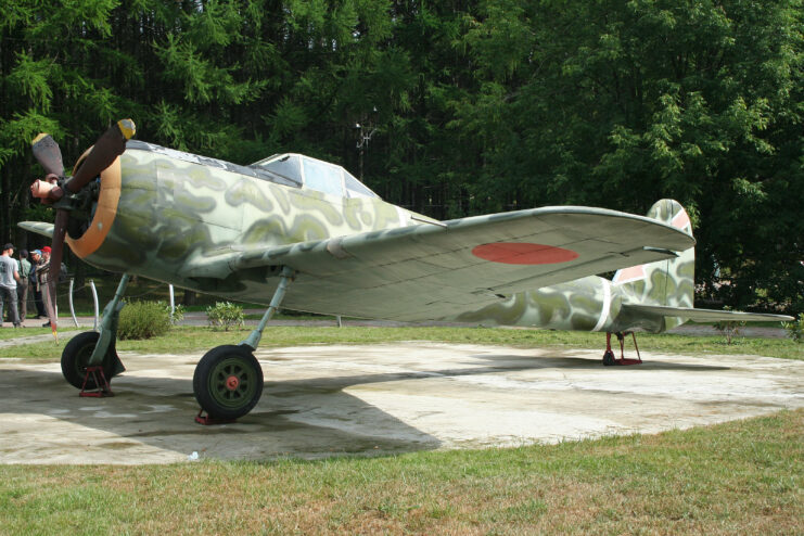 Nakajima Ki-43 Hayabusa on display in front of trees. 