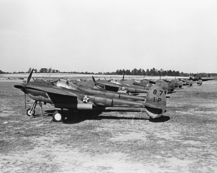 Lockheed P-38s lined up at an airfield. 