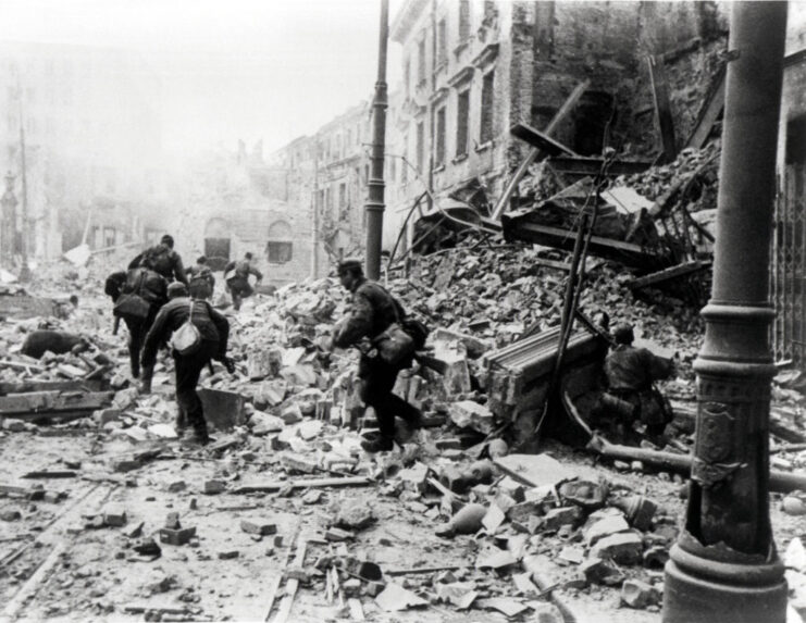 German and Polish Home Army soldiers running through a debris-ridden street