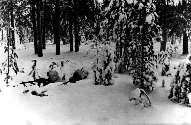 Finnish troops, almost invisible in their white clothing take up their positions on the Finnish-Russian front in wooded countryside