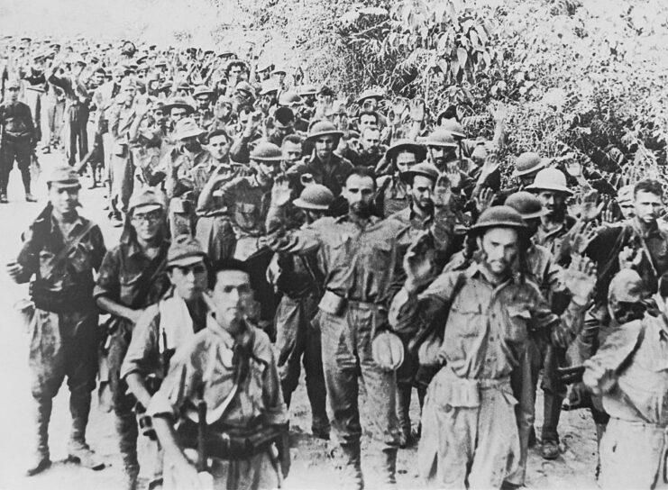 Allied prisoners of war (POWs) being led down a roadway by Japanese soldiers