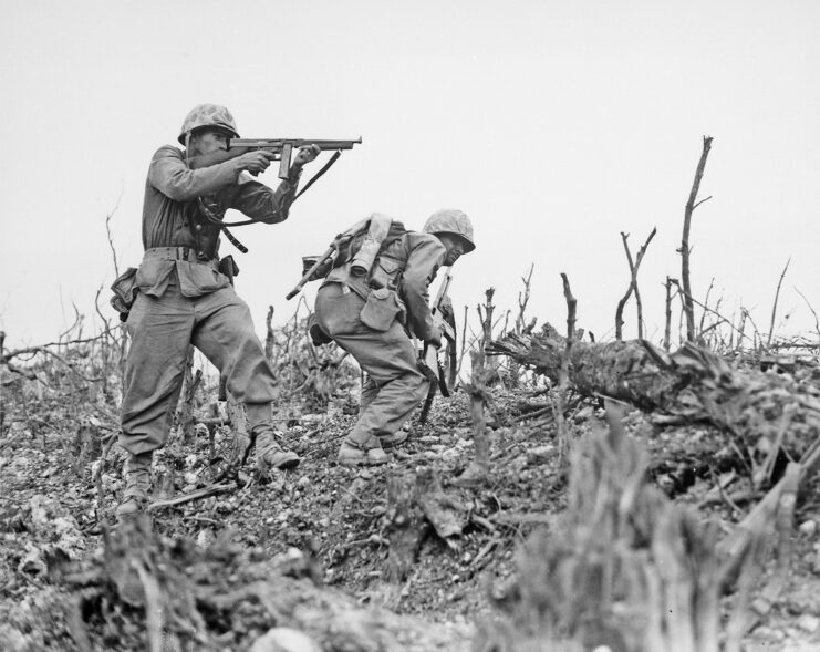 Two US Marines at Wana Ridge, one aiming his weapon and the other crouching