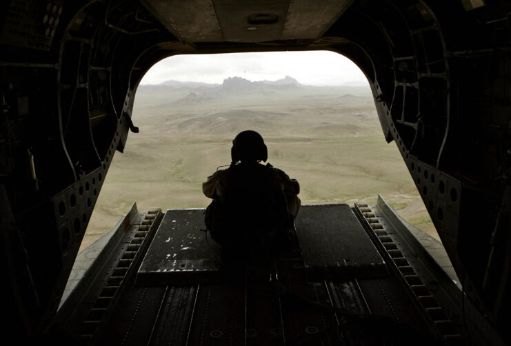 A tail gunner sitting in the rear of a US Army CH-47 Chinook.