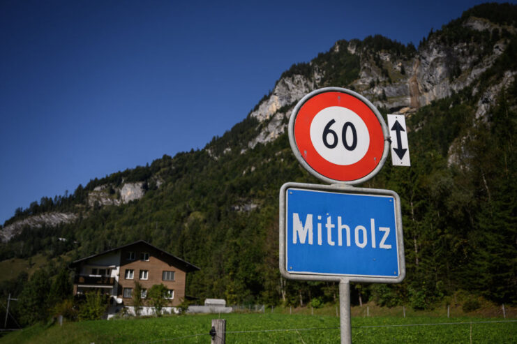 Combination speed and town sign outside of a mountainside residence