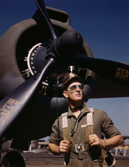 U.S. Army Lieutenant "Mike" Hunter stands in front of a Wright R-2600 Twin Cyclone engine of a Douglas A-20 Havoc twin-engine bomber.