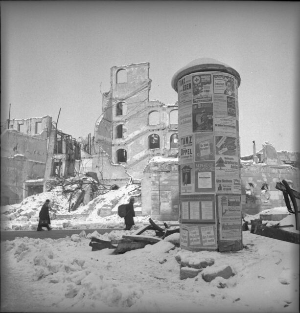 Residents walking past an advertising column