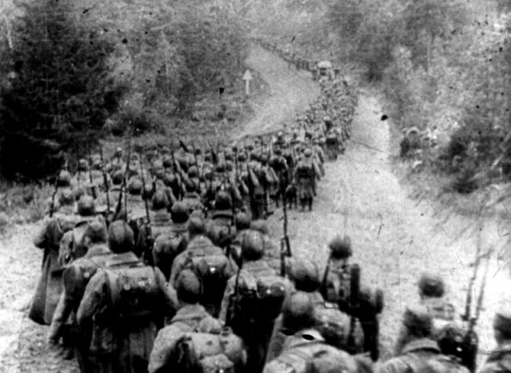 Red Army soldiers walking down a path in the middle of a wooded area