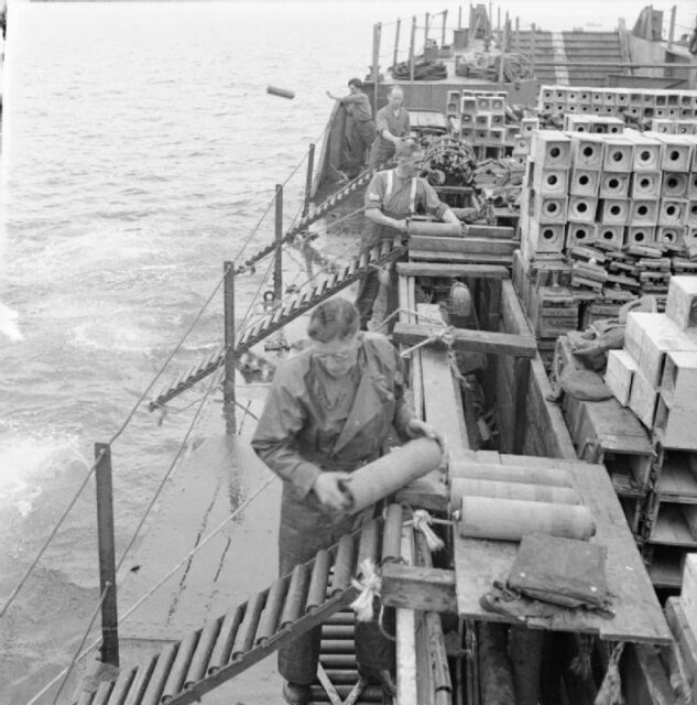 Members of the British Royal Army Ordnance Corps (RAOC) dropping munitions from the deck of a ship into the ocean