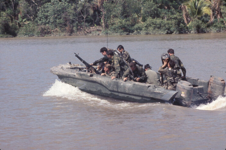 US Navy SEALs navigating a river in a SEAL Team Assault Boat (STAB)