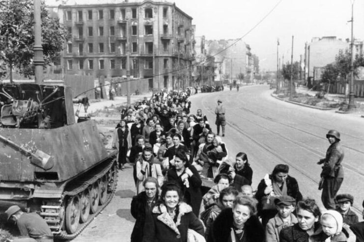 Women and children walking down Wolska Street, while German soldiers stand guard