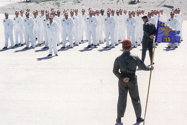 Aircraft maintenance crewmen with the 4477th Test & Evaluation Squadron lined up in front of a superior officer