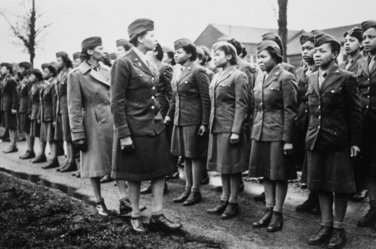 Charity Adams walking in front of members of the 6888th Central Postal Directory Battalion, who are standing together