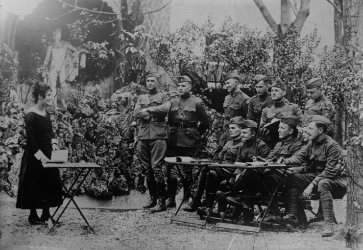 Female teacher standing before a group of American soldiers