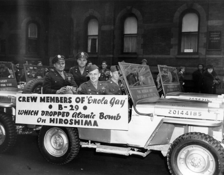 Crew of the Boeing B-29 Superfortress 'Enola Gay' riding in the back of a vehicle