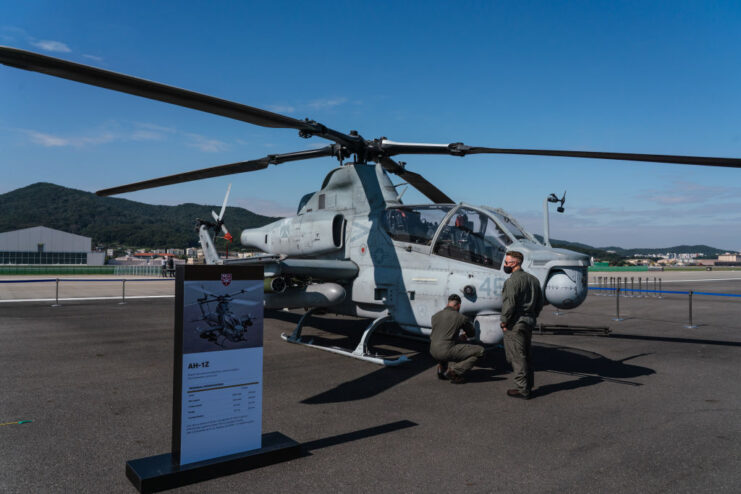 Two US Army soldiers standing near a Bell AH-1Z Viper