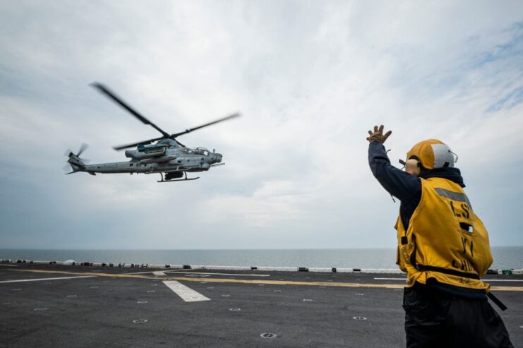 Crewman waving a Bell AH-1Z Viper toward the flight deck of the USS Kearsarge (LHD-3)