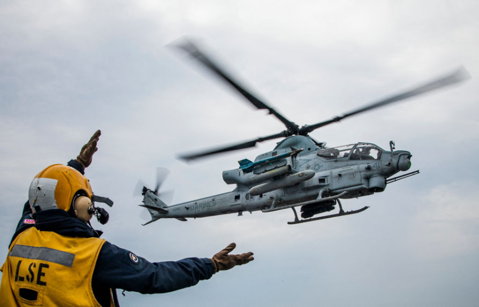 Crewman waving a Bell AH-1Z Viper toward the flight deck of the USS Kearsarge (LHD-3)