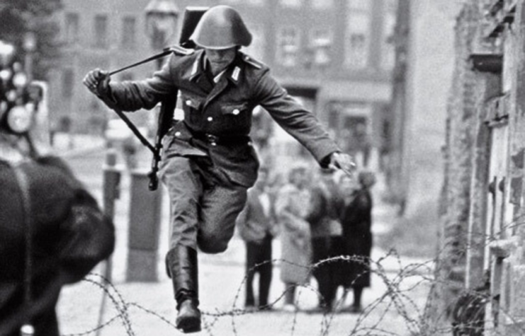 Conrad Schumann jumping over the barbed wire fence between East and West Berlin