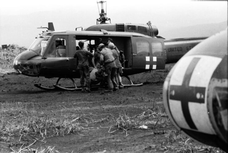 Ground crewmen loading an injured soldier into a Bell UH-1 Huey