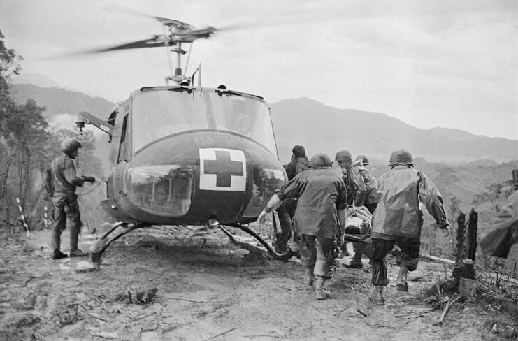 MEDEVAC crew loading an injured soldiers onto a Bell UH-1 Huey