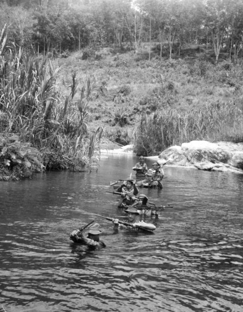 Soldiers walking across a deep river