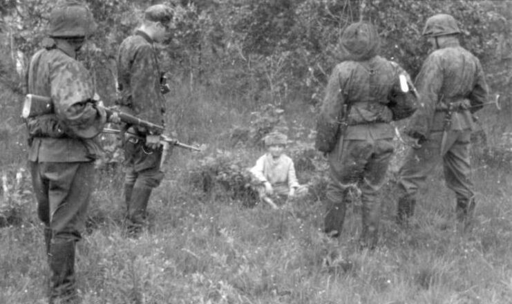 Four SS officers standing around a little boy