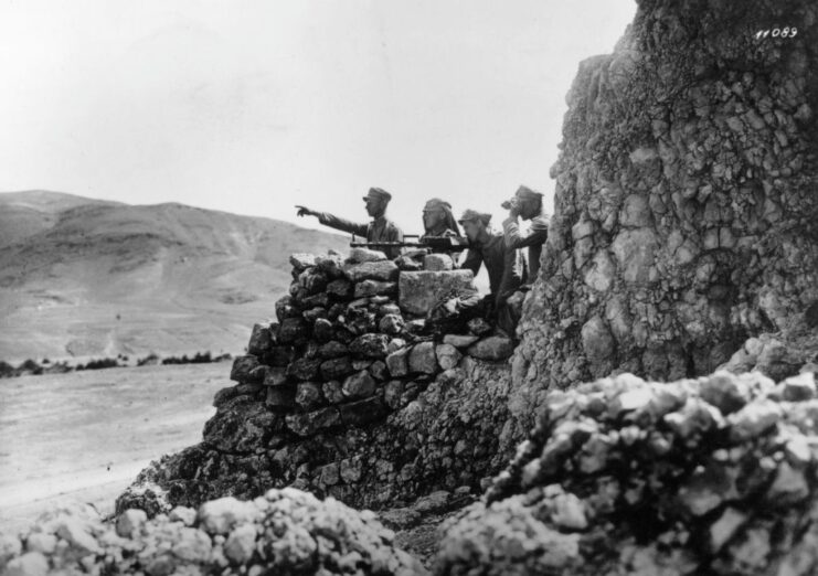 Soldiers manning a machine gun position on the edge of a cliff