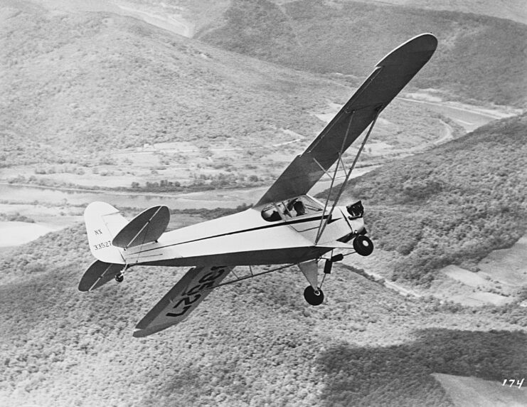 Piper J-3 Cub during an in-flight banked turn. Black and white.