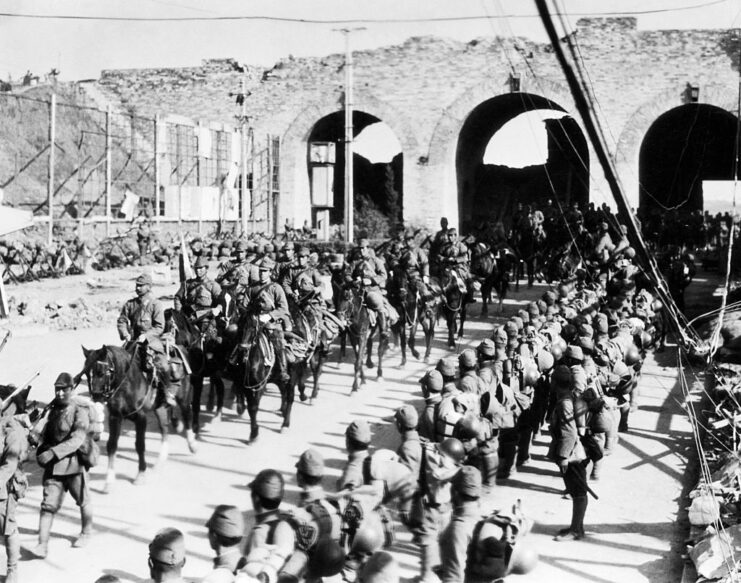 Japanese troops, on foot and on horseback, walking down a road