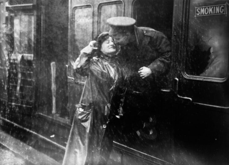 British soldier leaning out of a train window to give a woman a kiss on the cheek