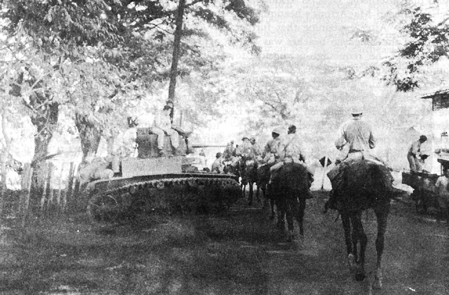 Members of the 26th Cavalry Regiment riding on horseback past an M3 Stuart