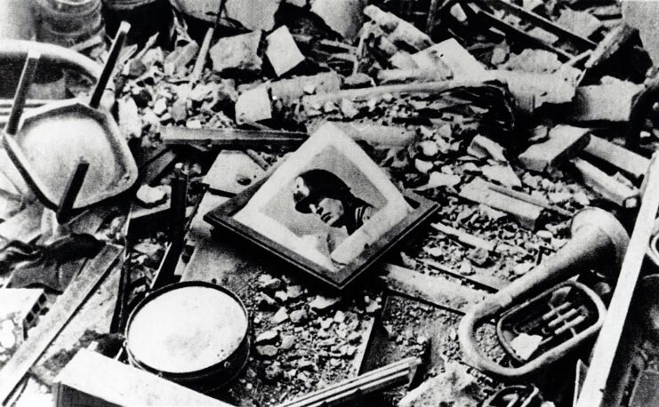 Portrait of Benito Mussolini atop a pile of rubble