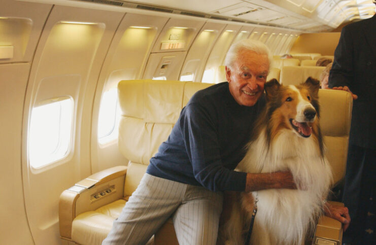 Bob Barker sitting on a private jet with a border collie