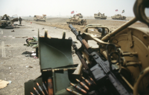 British armored fighting vehicles (AFVs) driving along Highway 80, also known as the Highway of Death