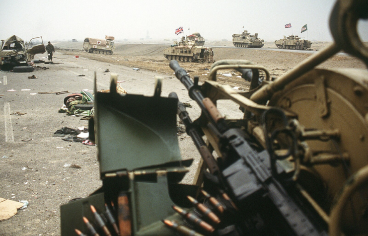 British armored fighting vehicles (AFVs) driving along Highway 80, also known as the Highway of Death