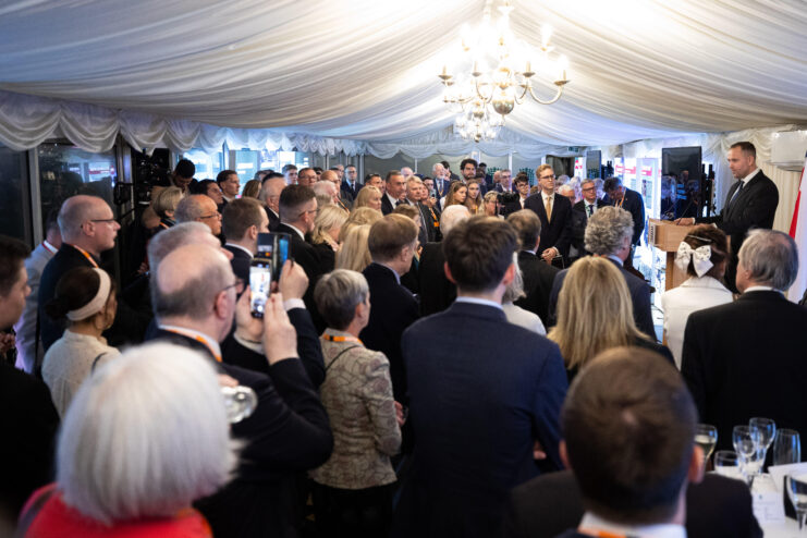 Crowd gathered around a man speaking at a podium