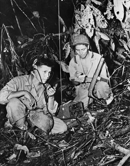 Two Navajo code talkers using a portable radio system in the jungle