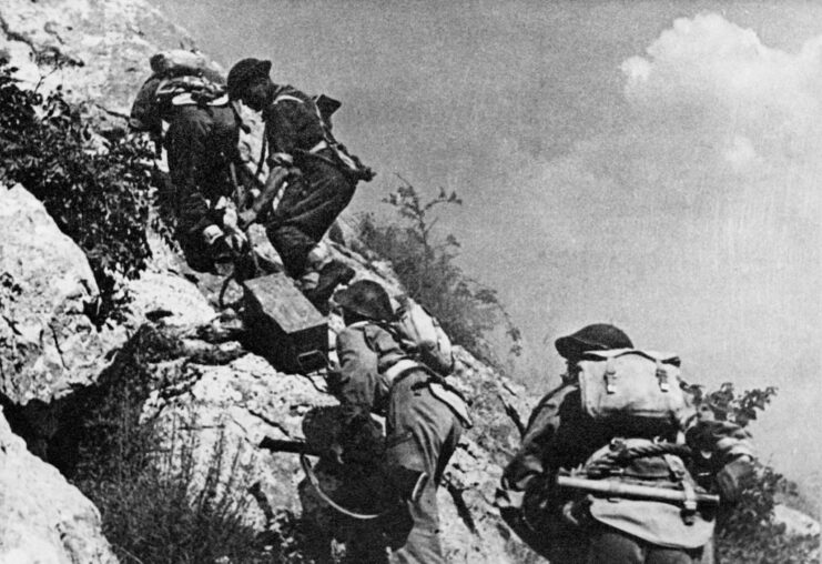 Soldiers with the 3rd Carpathian Rifles Division climbing up a rocky hill