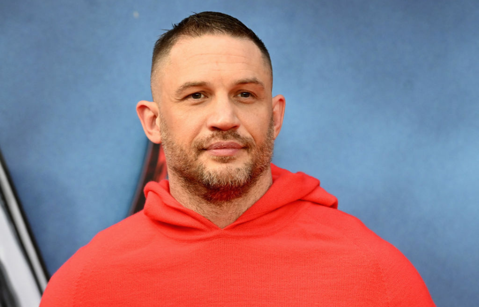 Tom Hardy standing on a red carpet