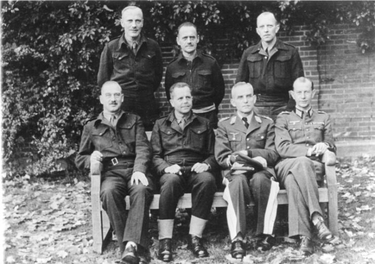 Otto Elfeldt, Ferdinand Heim, Gerhard Bassenge, Friedrich Freiherr von Broich, Heinrich Eberbach, Georg Neuffer and Hans Reimann standing together near a large hedge