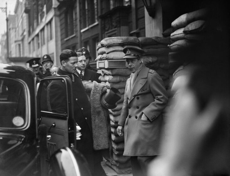 Edward VIII walking out of the sandbag-reinforced entrance of Claridges Hotel