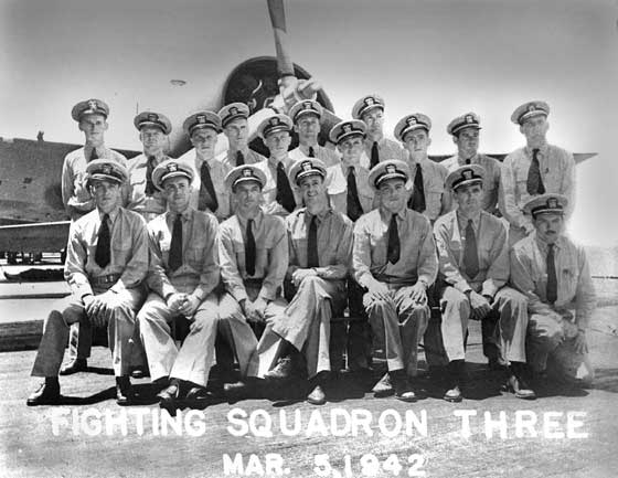 Members of Fighter Squadron 3 (VF-3) sitting and standing in front of an aircraft