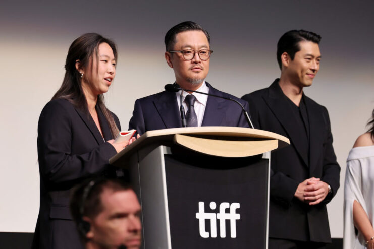 Members of the cast and crew of 'Harbin' standing at a podium on stage