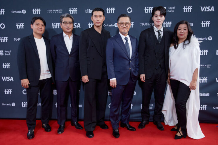 Six members of the cast and crew involved in 'Harbin' standing on a red carpet